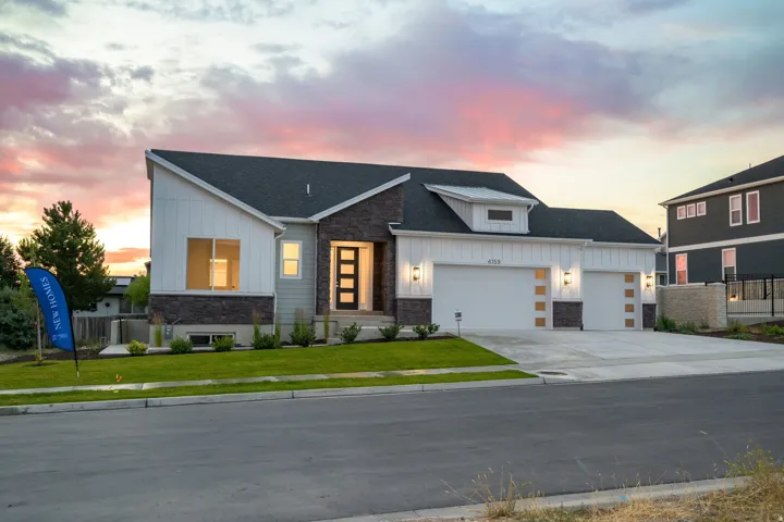 Modern architectural facade featuring mixed materials, a dark-toned roof, and white vertical siding