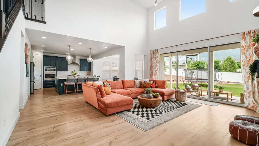 Spacious living area featuring high ceilings, wood-finish flooring, and expansive sliding glass doors