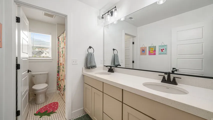 Double vanity featuring integrated sinks, light-toned countertops, and matte black fixtures