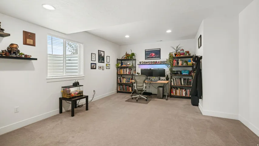 Carpeted room featuring a single window with blinds, recessed lighting, and white walls with baseboards