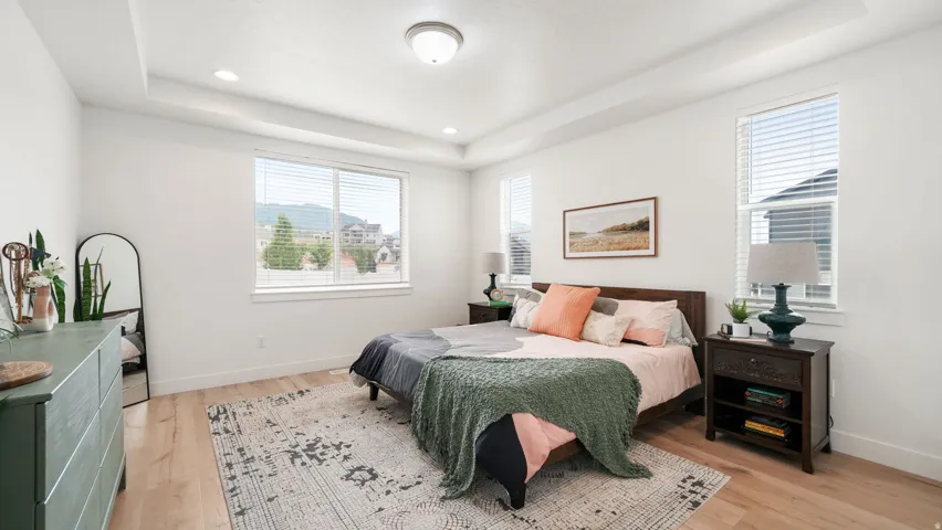 Spacious bedroom with light wood-finish flooring