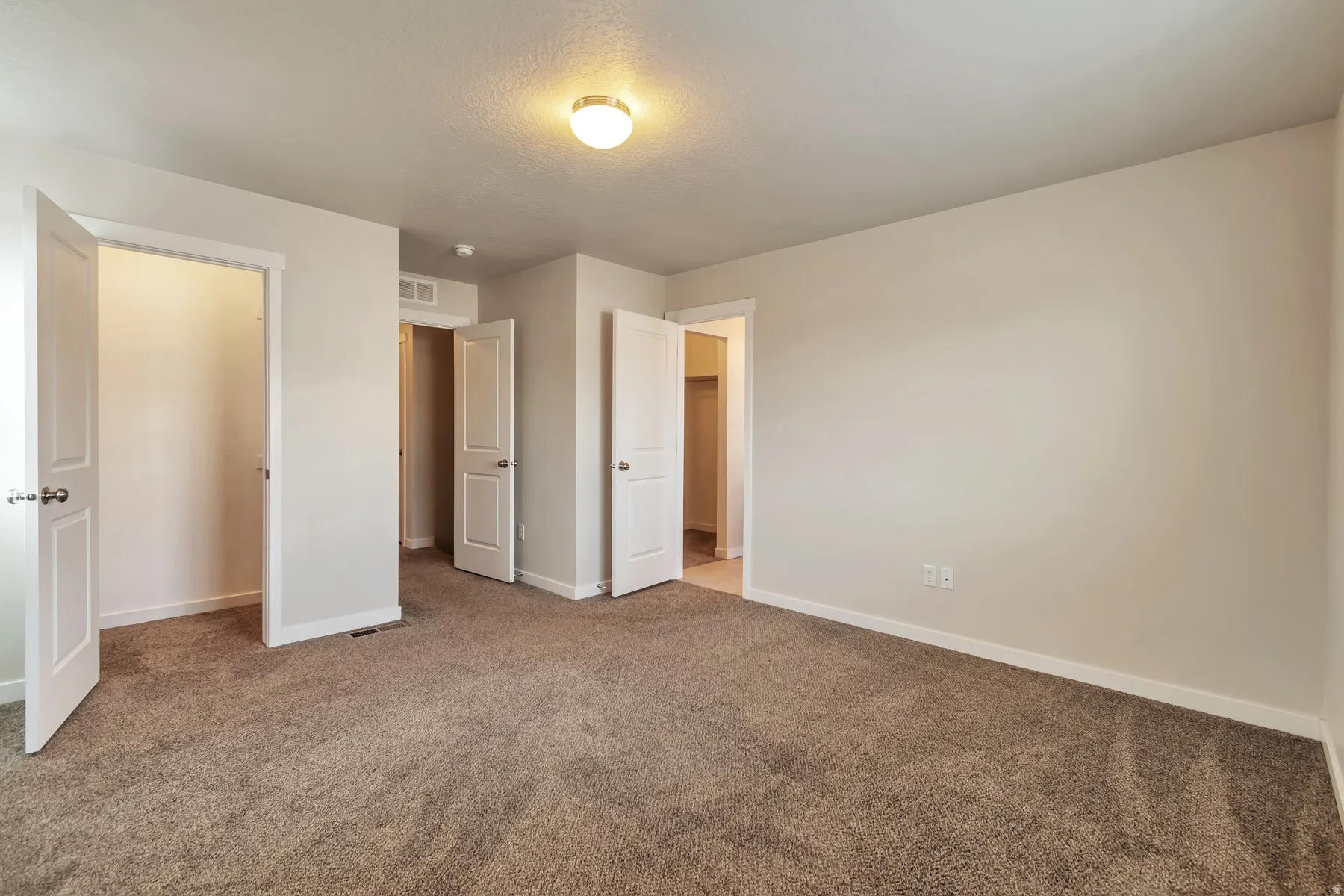 Spacious room featuring neutral carpeting and light-toned walls