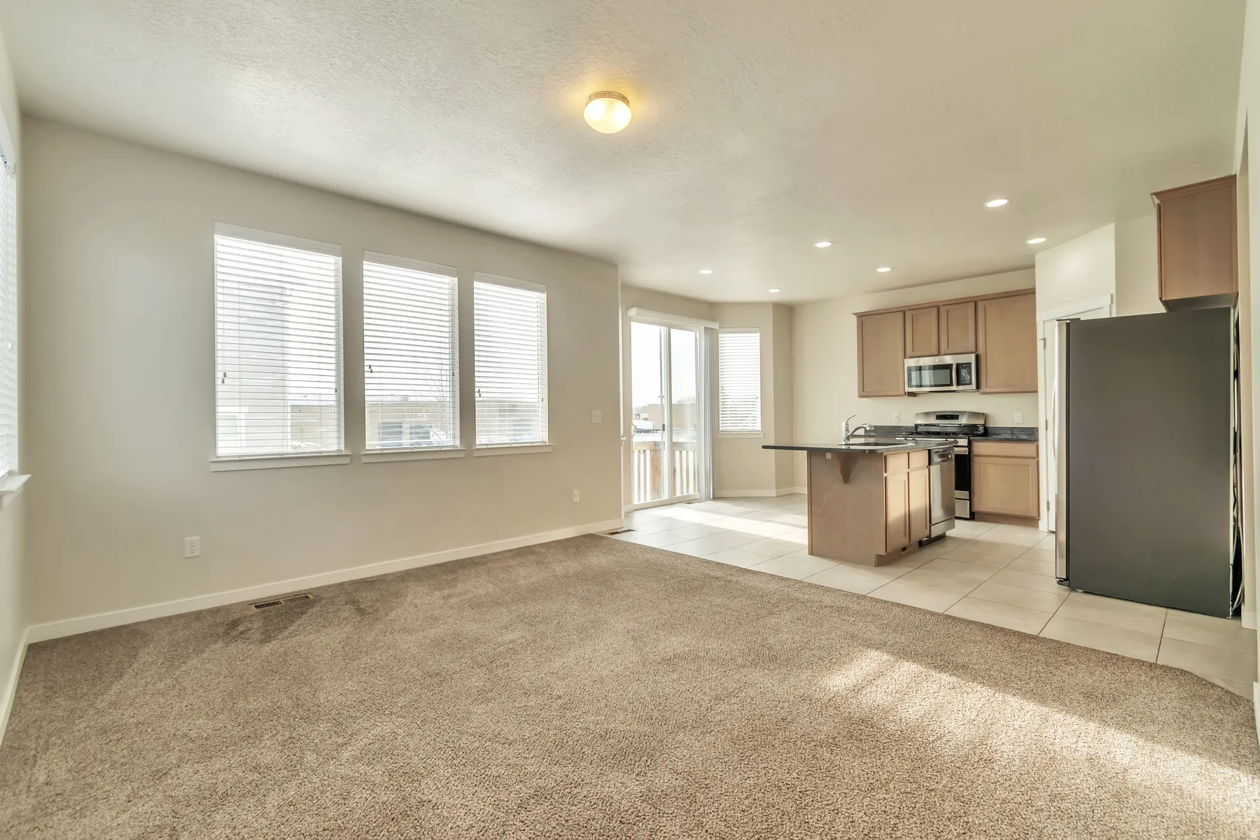 Open-concept living space featuring neutral-toned walls and carpet flooring
