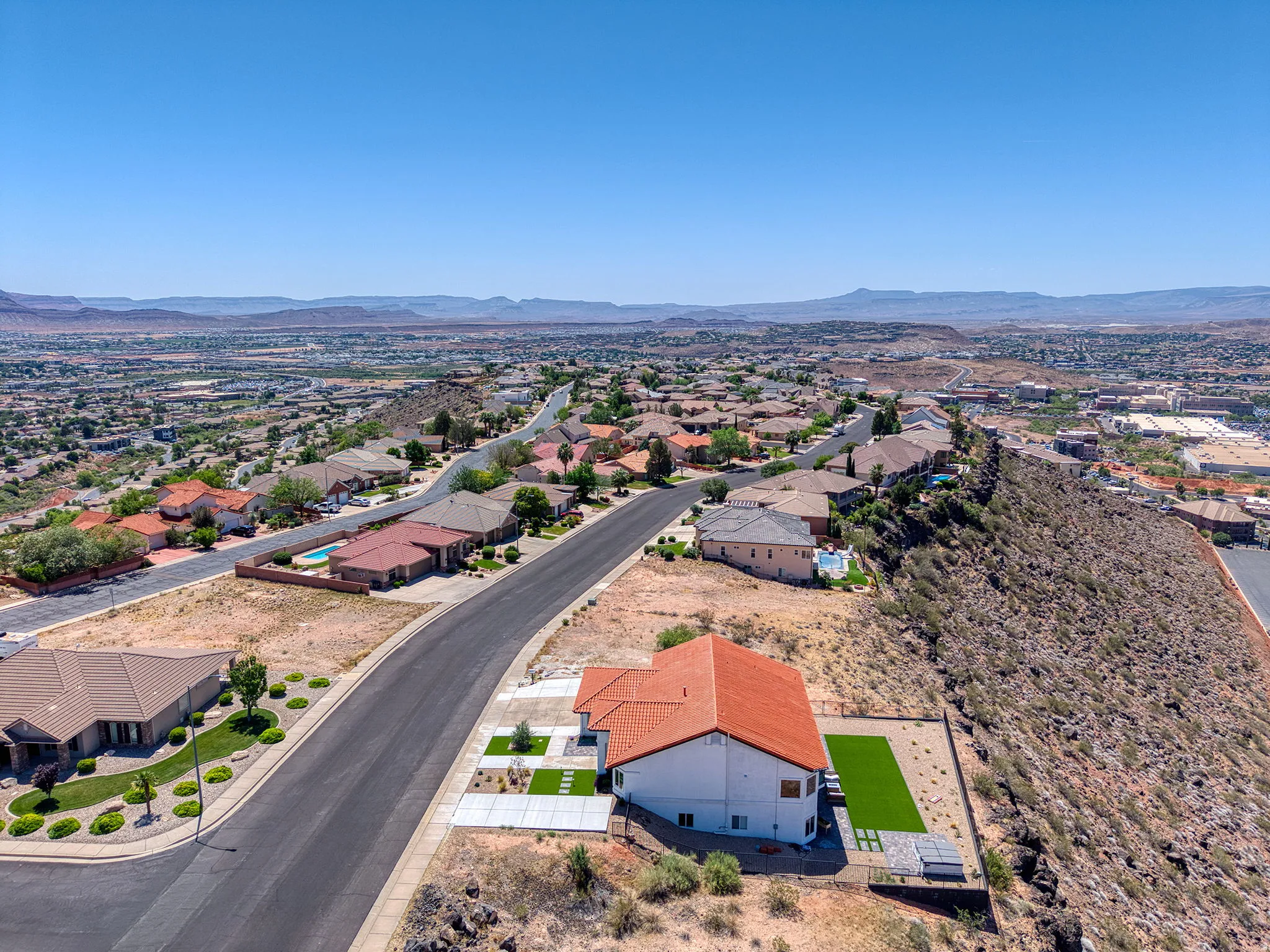 Aerial perspective showcasing a residential neighborhood with distant mountain ranges