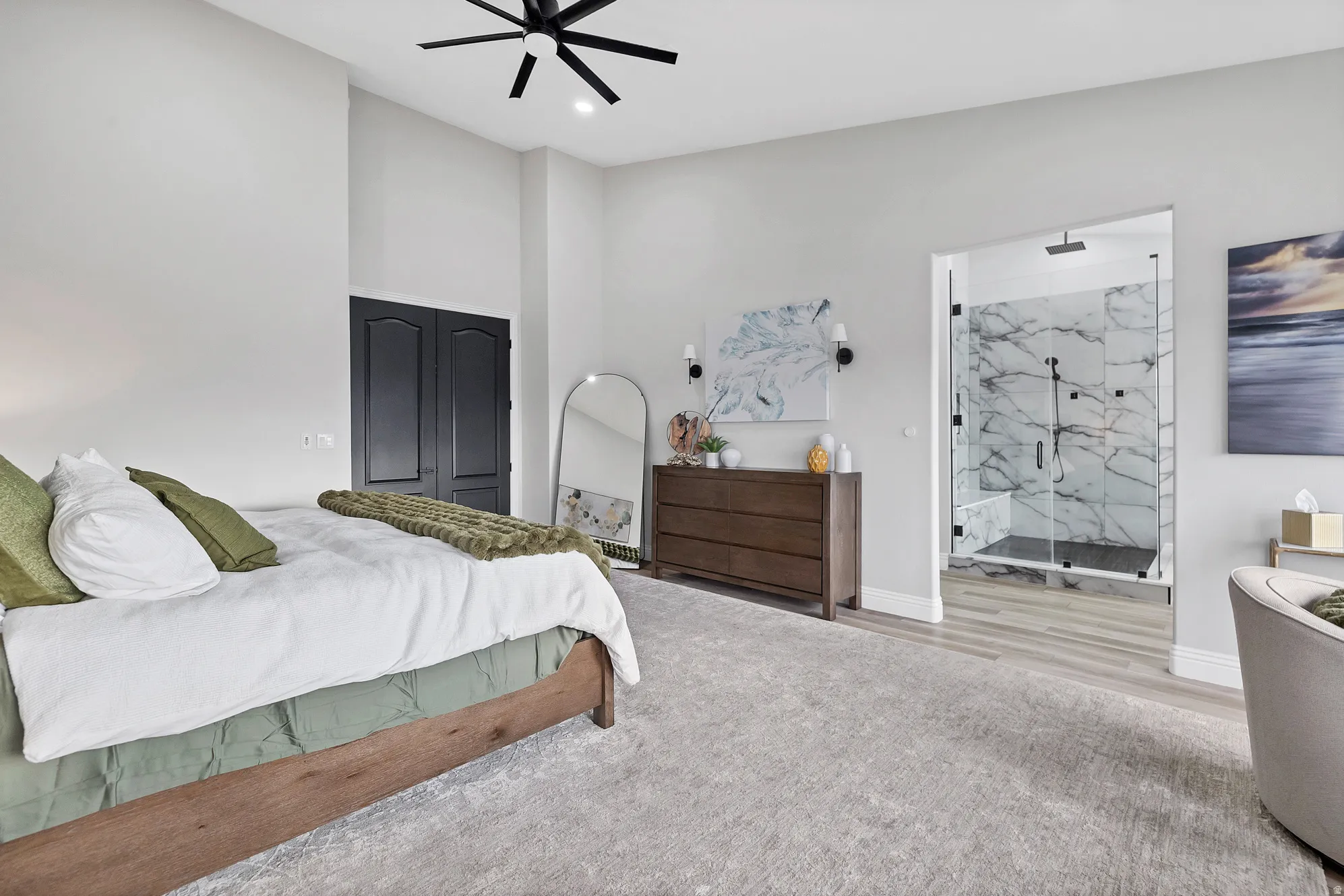 Spacious room featuring vaulted ceilings, a contemporary ceiling fan, and light gray wall finishes