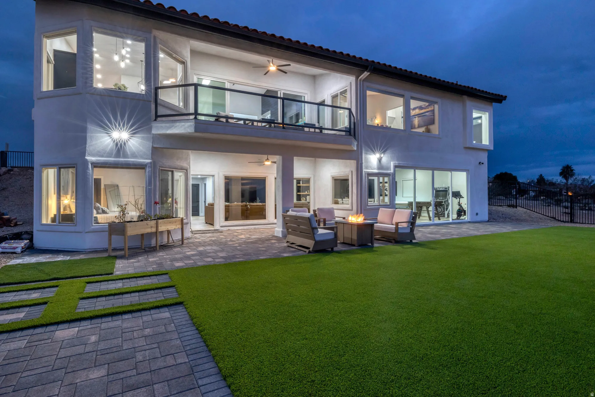 Spacious backyard with artificial turf lawn, paver patio, and multi-level exterior