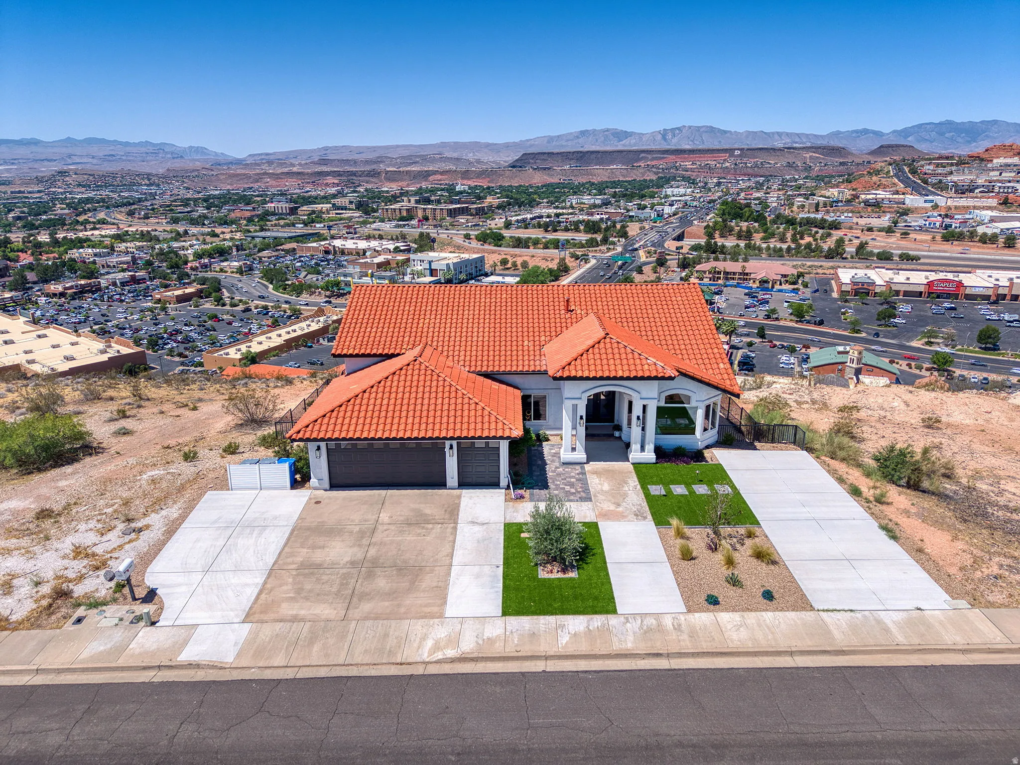 White stucco residence featuring a terra cotta tile roof and attached two-car garage