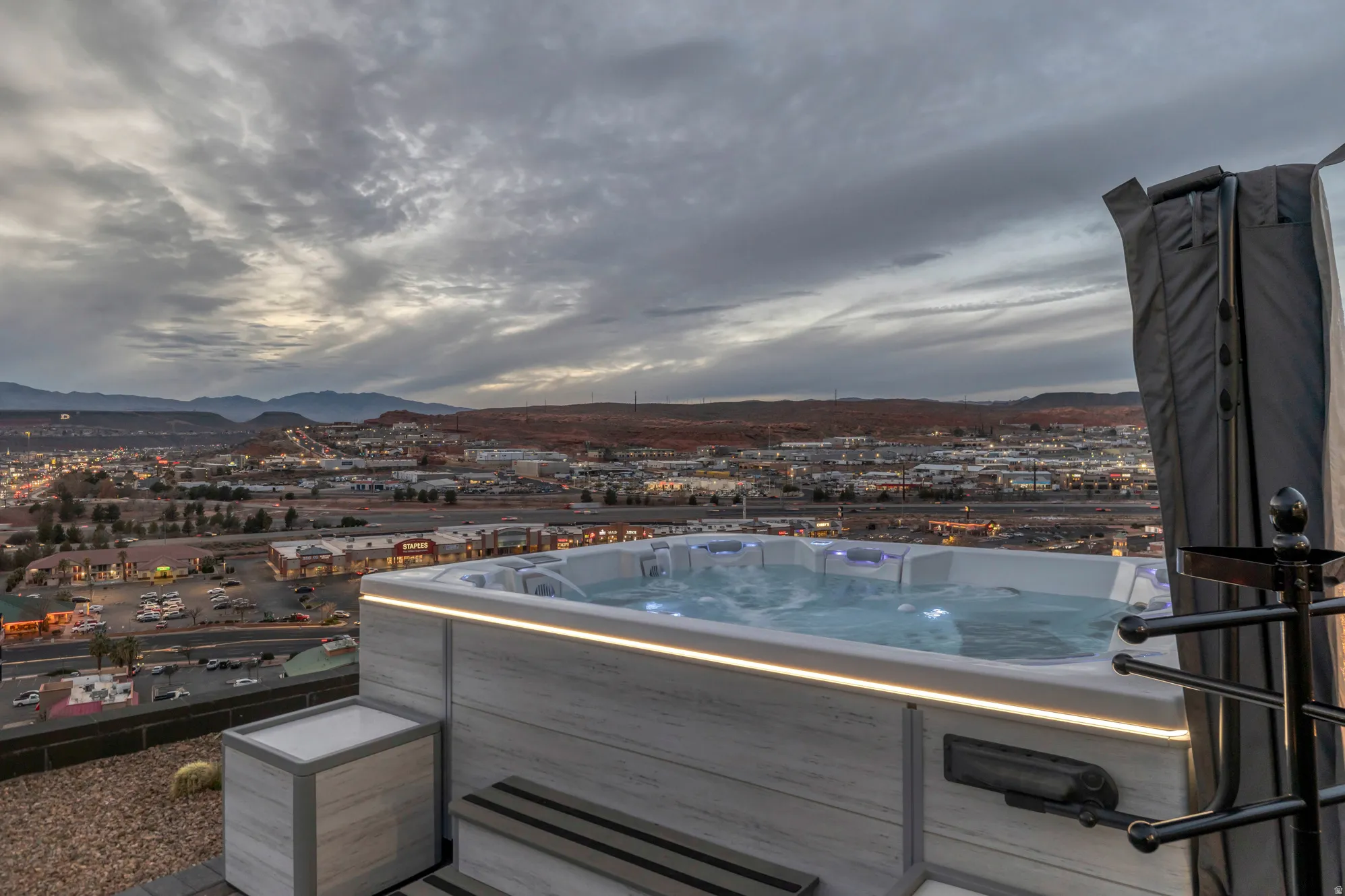 Outdoor hot tub featuring integrated lighting, a multi-jet design, and a light-toned wood-finish exterior