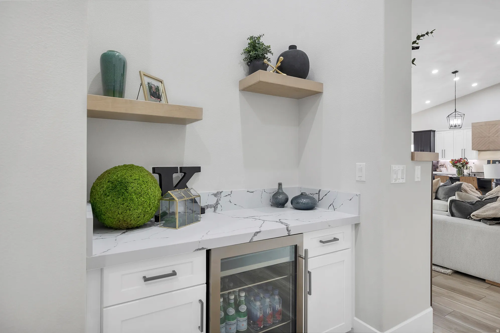 Integrated wet bar featuring white cabinetry, a stone-finish countertop, and a built-in beverage refrigerator