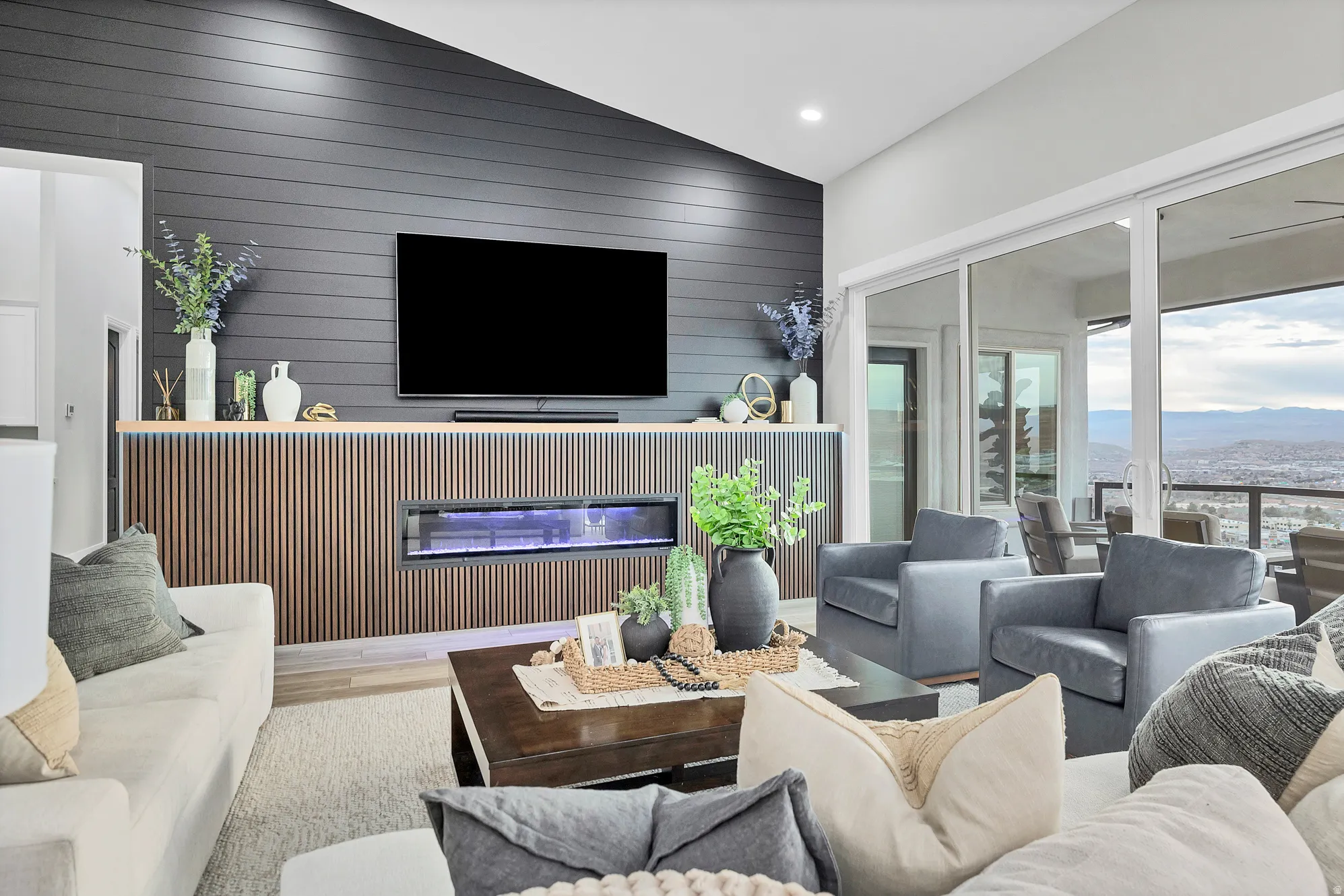 Open-concept living space featuring a linear fireplace with wood slat detailing, a shiplap accent wall, recessed lighting, and wood-finish flooring