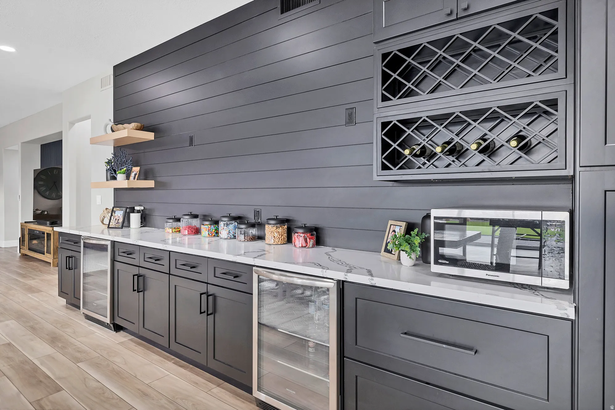 Custom built-in cabinetry with a white countertop and contrasting dark gray shiplap accent wall