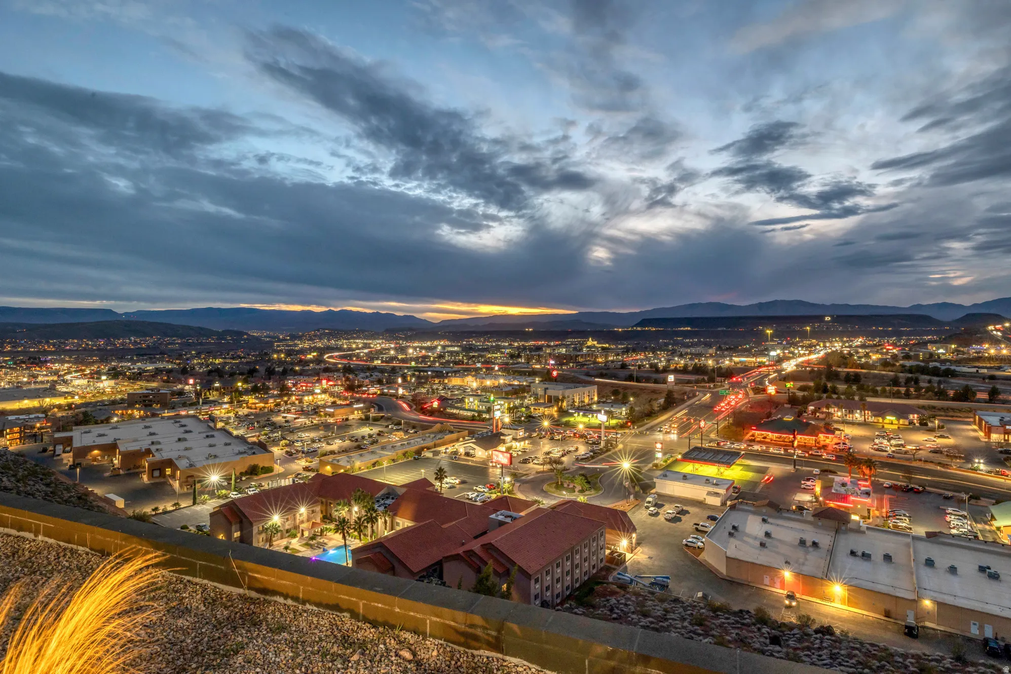 Expansive city lights with distant mountain ranges under a twilight sky