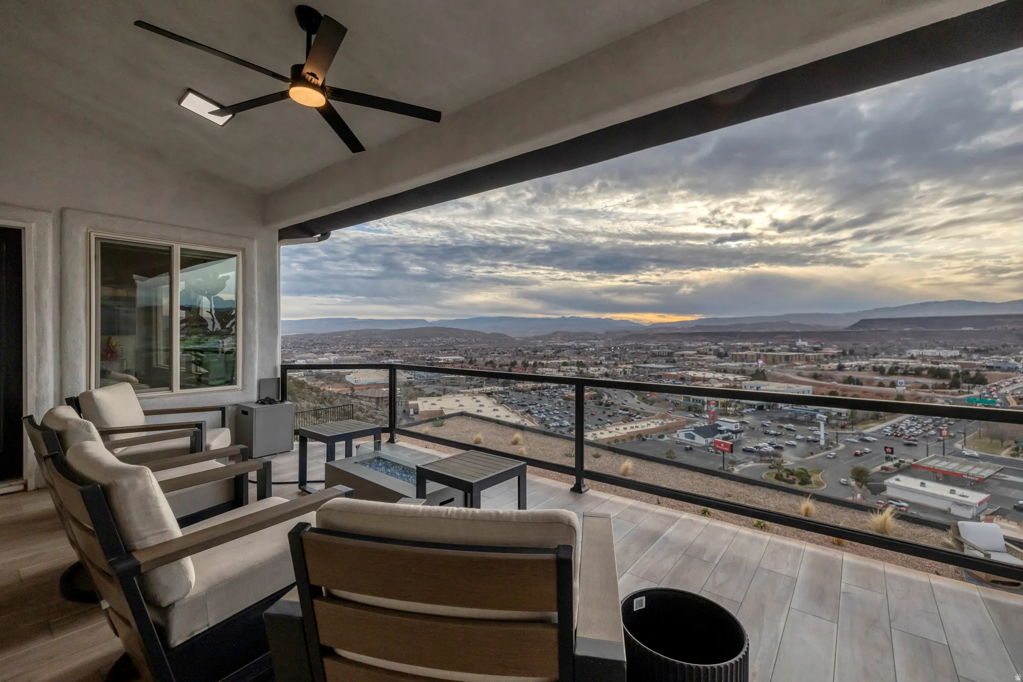 Spacious covered patio featuring plank-style tile flooring and a ceiling fan