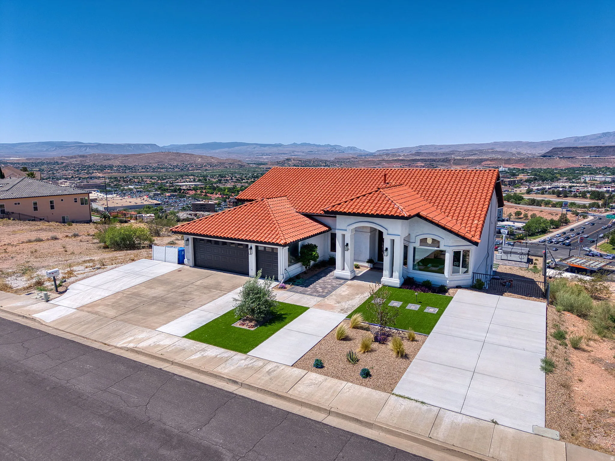 Mediterranean-style residence featuring a terracotta tile roof and white exterior