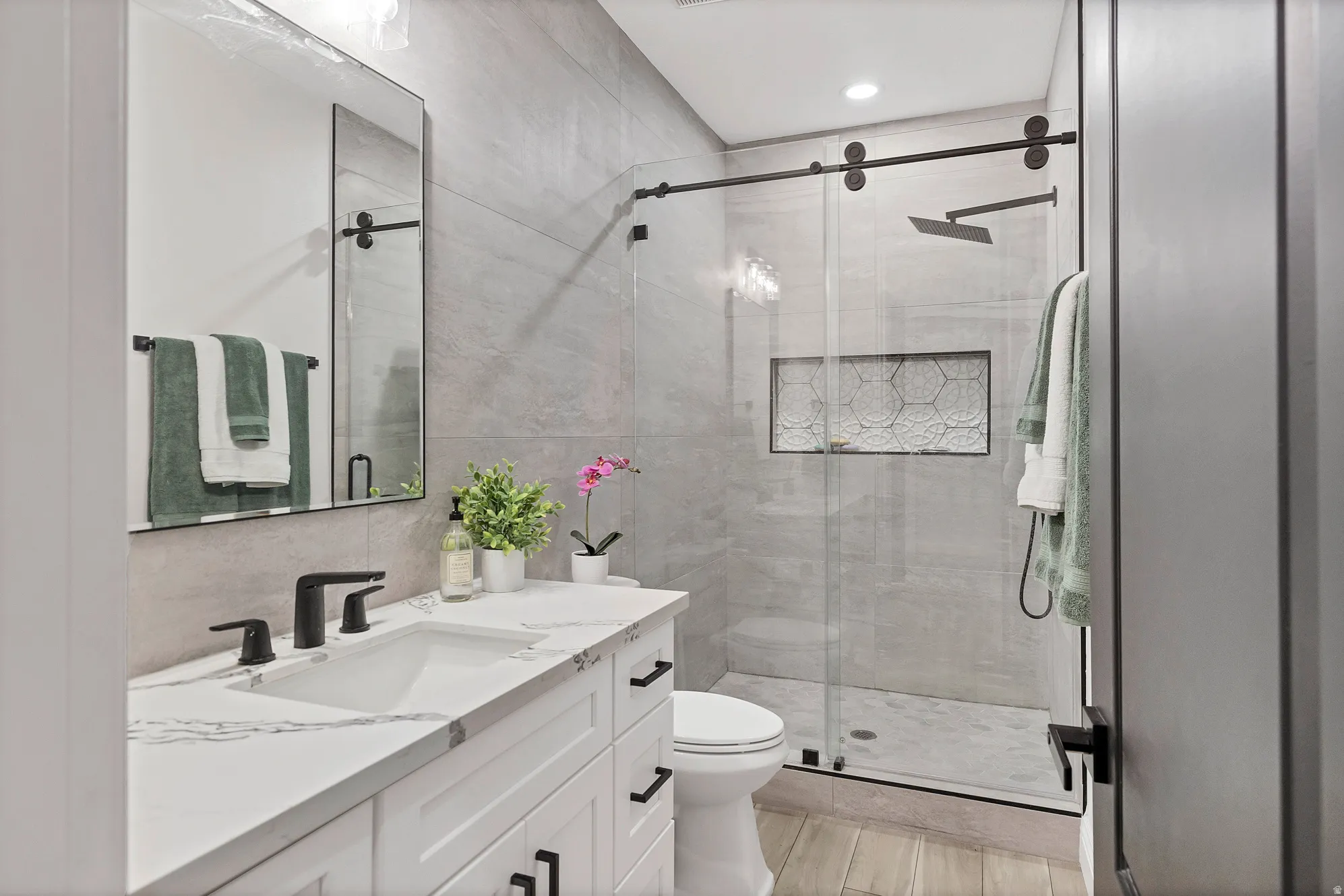 Modern bathroom featuring a white vanity with a rectangular sink and matte black fixtures