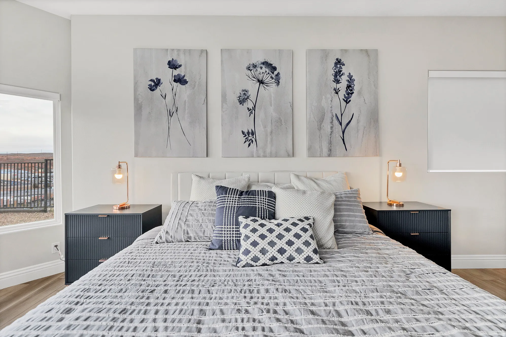 Bedroom featuring a window with exterior visibility, wood-finish flooring, and white baseboards