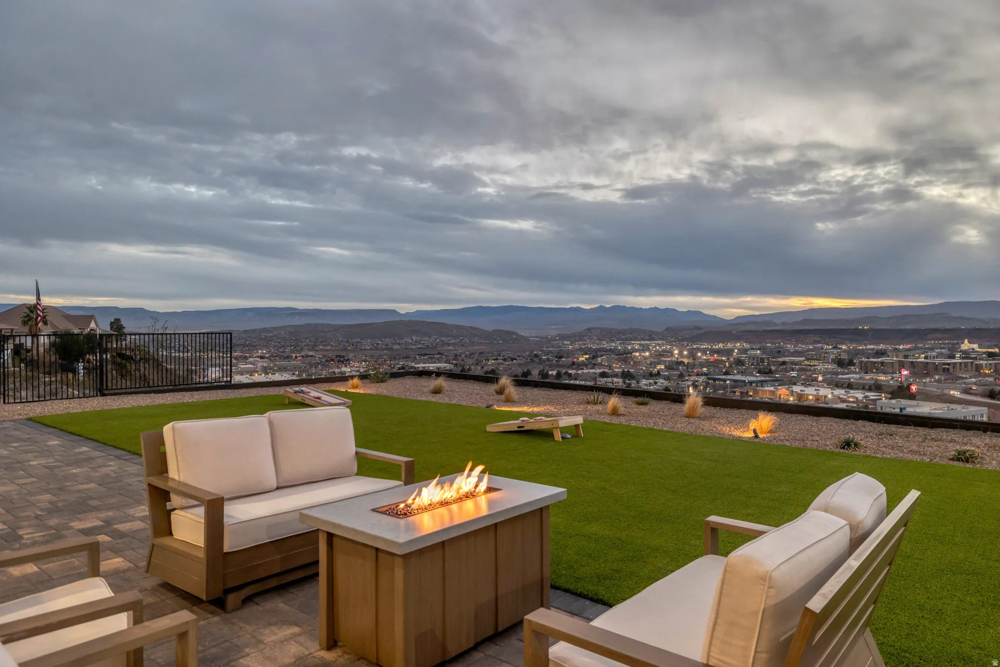Spacious outdoor patio featuring paver flooring, a gas fire pit, and synthetic turf