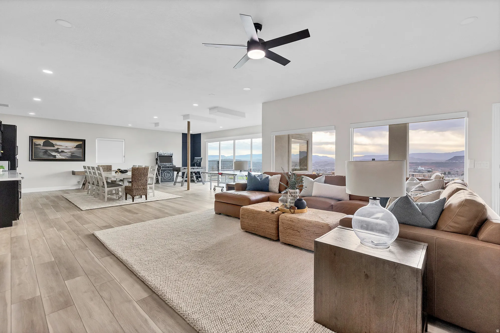 Expansive open-concept living space featuring wood-finish flooring, recessed lighting, and a contemporary ceiling fan