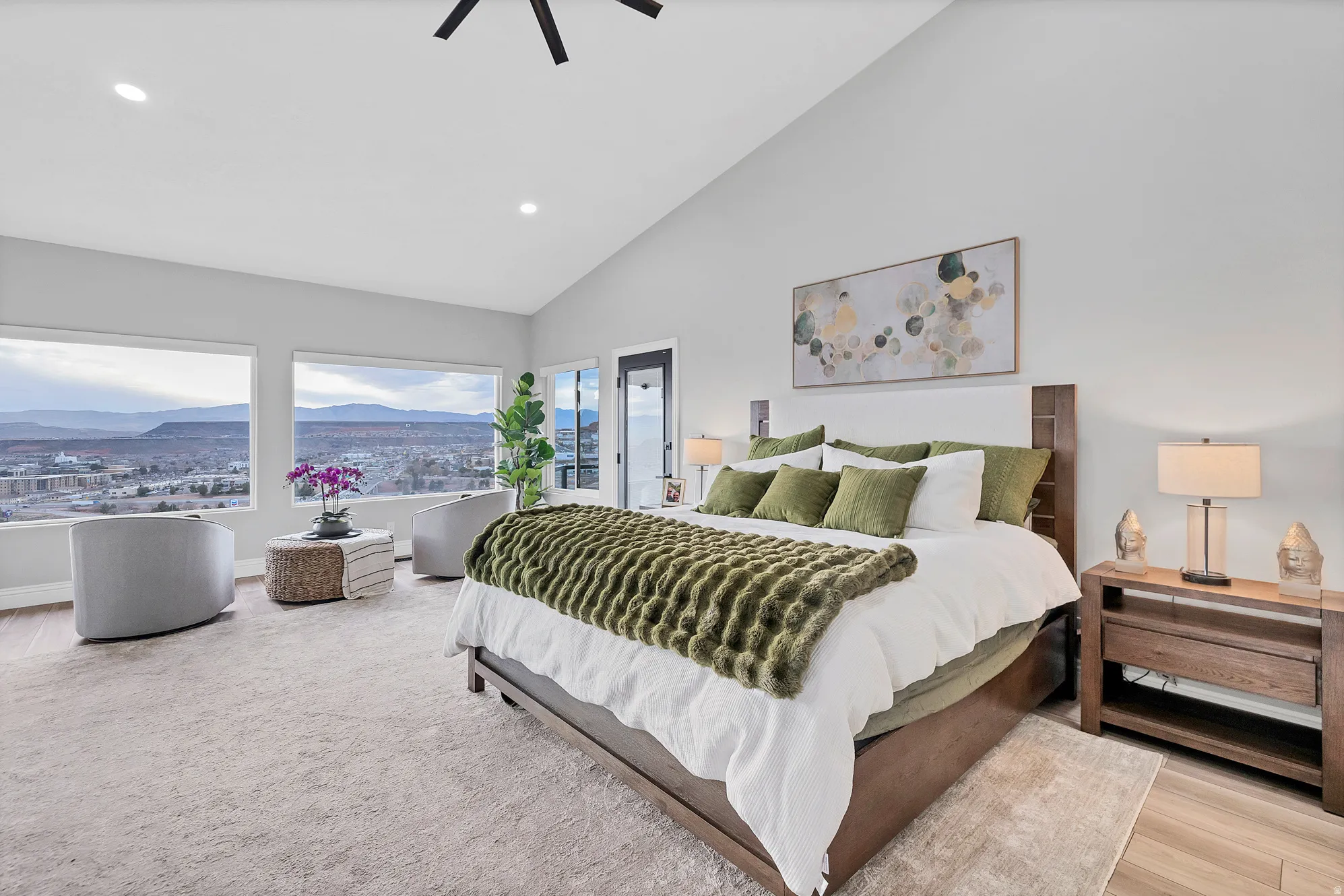 Expansive room featuring multiple large windows, vaulted ceilings, recessed lighting, and wood-finish flooring