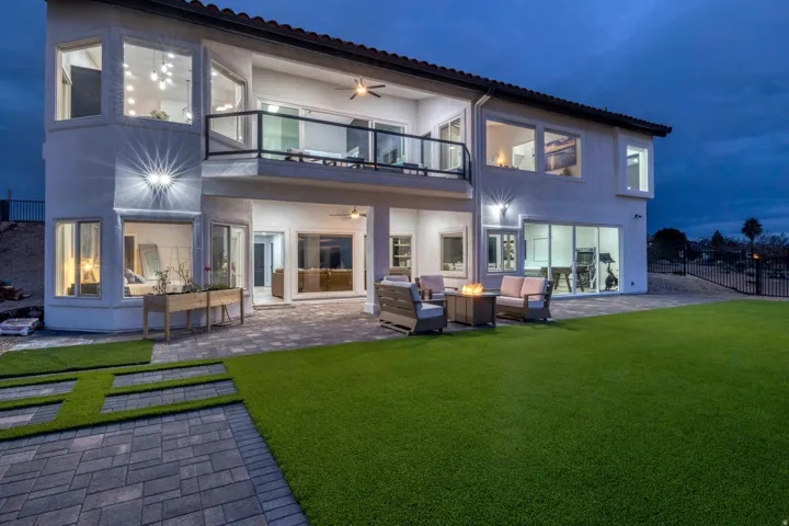 Spacious backyard with artificial turf lawn, paver patio, and multi-level exterior