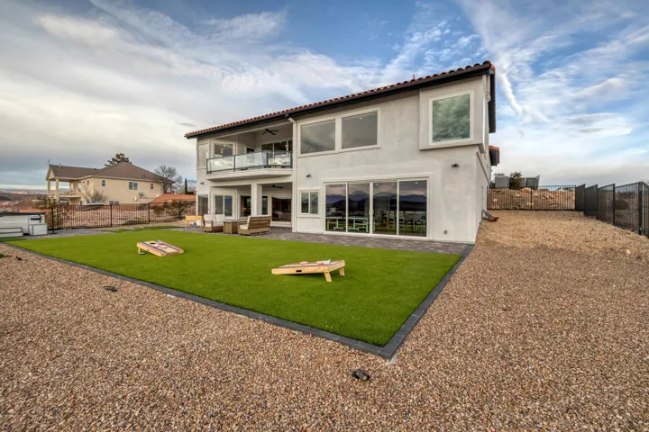 Rear exterior featuring a stone tile roof and stucco siding