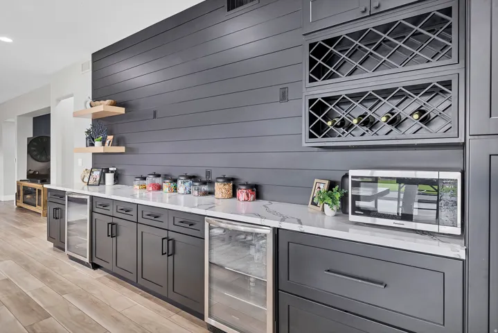 Custom built-in cabinetry with a white countertop and contrasting dark gray shiplap accent wall