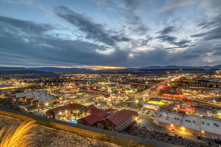 Expansive city lights with distant mountain ranges under a twilight sky