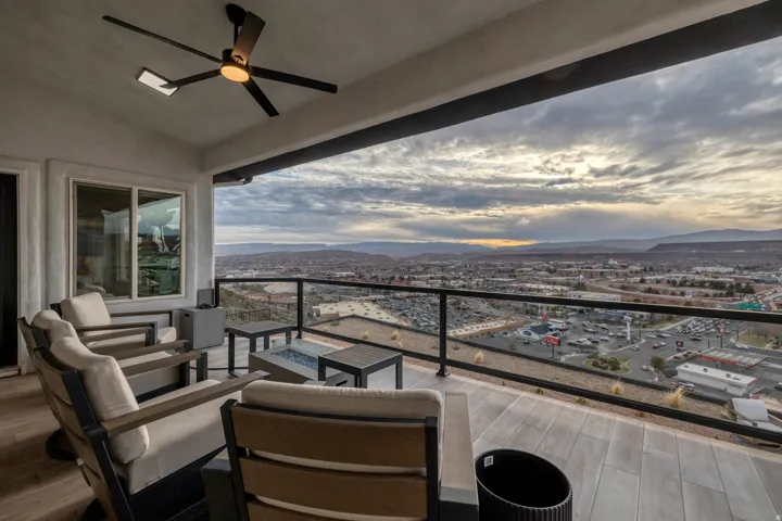 Spacious covered patio featuring plank-style tile flooring and a ceiling fan
