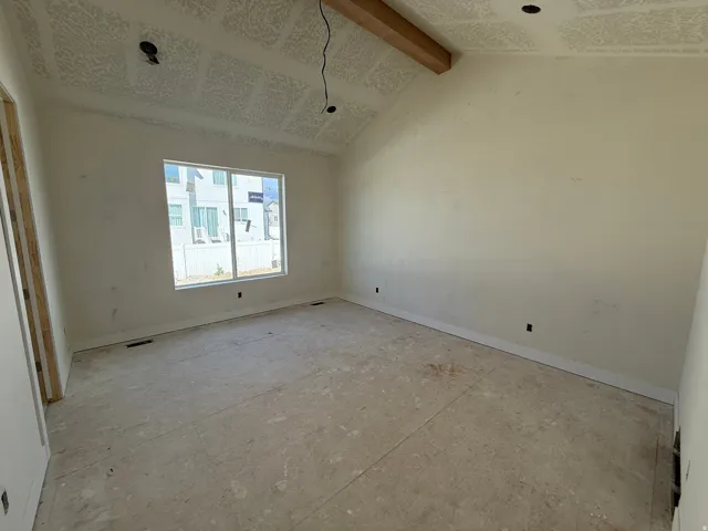 Primary Bedroom featuring Vaulted ceiling with exposed wood beam, recessed lighting, and a large window