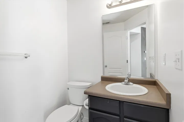 Bathroom vanity featuring a built-in sink, dark cabinetry, and neutral countertop