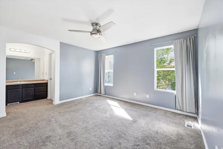 Spacious room featuring gray carpeting and light blue walls
