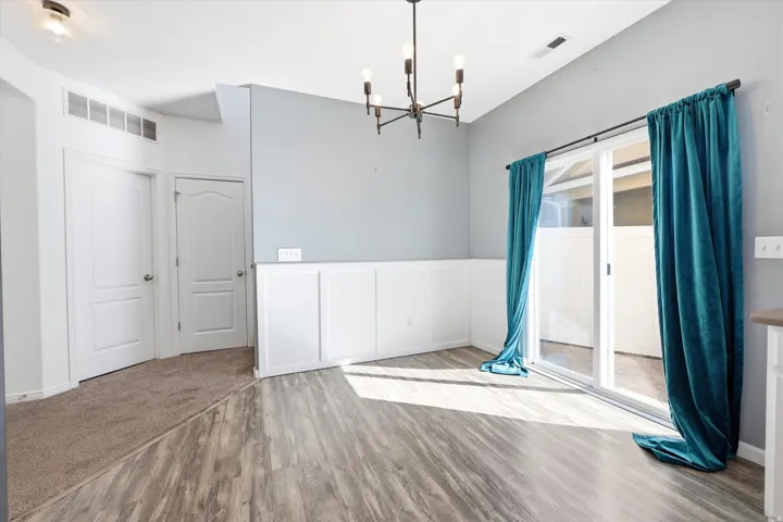 Interior space featuring wood-finish flooring, wainscoting, and a sliding glass door