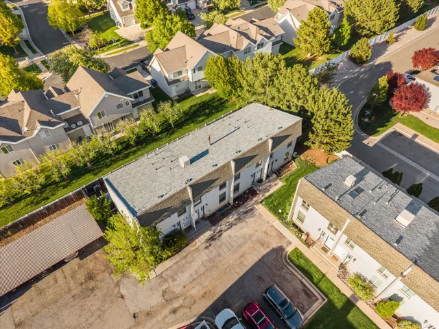 Aerial perspective showcasing a multi-unit residential property with a shingle roof and light-colored exterior