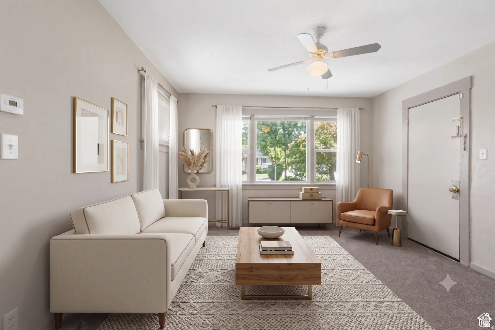 Bright living area featuring a large window, neutral wall paint, ceiling fan, and carpeted flooring