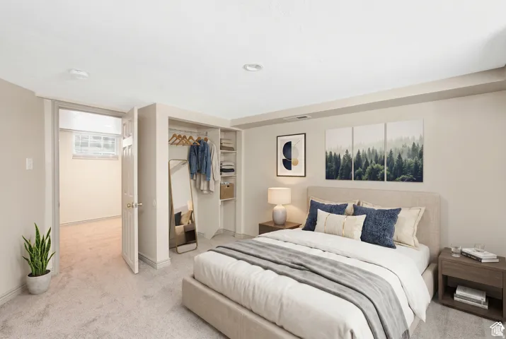 Carpeted bedroom featuring recessed lighting, a built-in closet with shelving and hanging space, and a white interior door