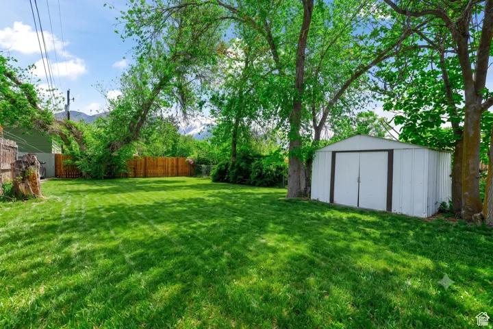 Expansive green lawn with mature trees and a fenced perimeter