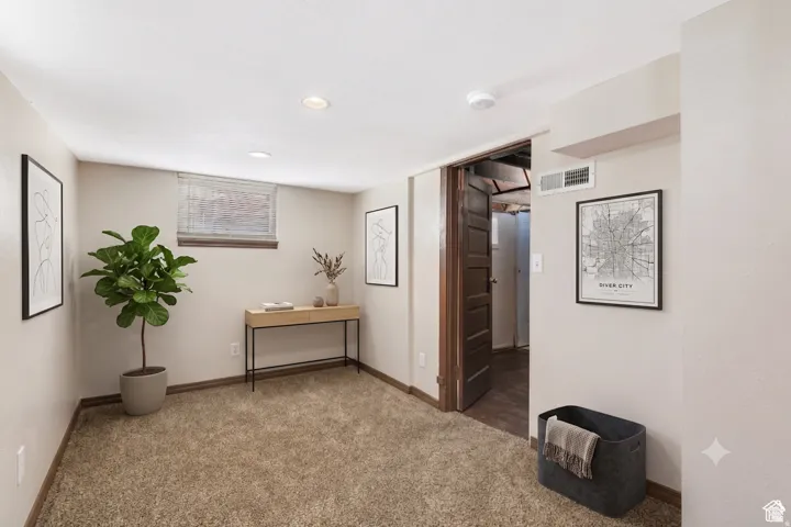 Carpeted room with recessed lighting and a single window featuring blinds