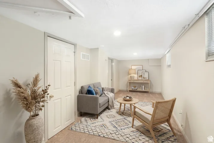 Carpeted lower-level room featuring recessed lighting, a window with blinds, and painted walls