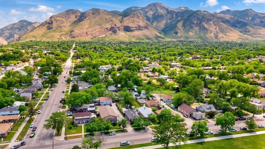 Expansive community featuring residential properties, mature trees, and mountainous terrain