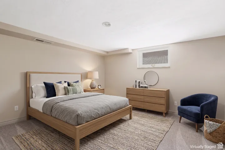 Recessed lighting illuminates this room featuring light-toned walls and plush carpeting