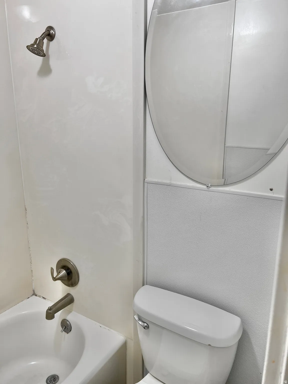 White tub-shower combination with brushed nickel fixtures