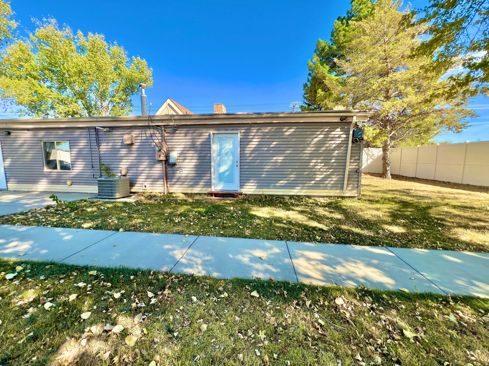 Rear elevation featuring horizontal siding, a white entry door, a single window, and a visible HVAC unit