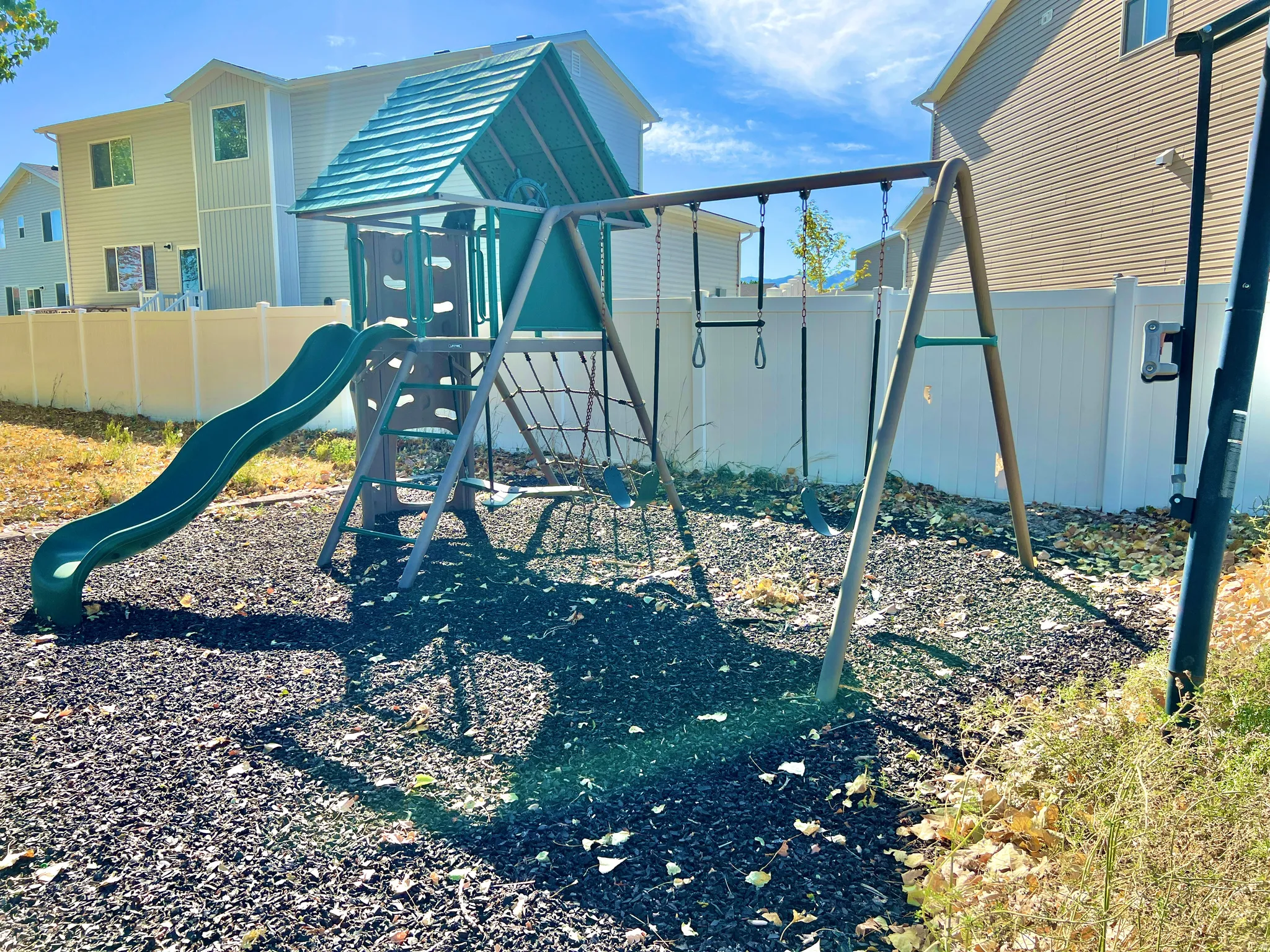 Outdoor play structure featuring a slide, swings, and climbing elements
