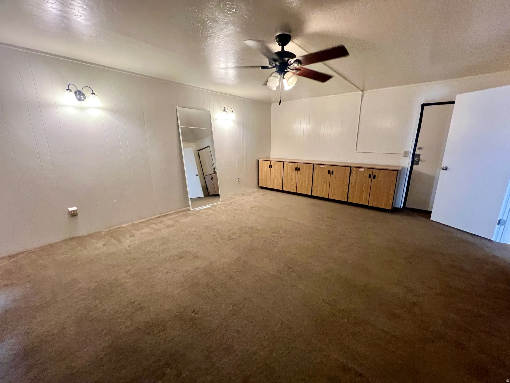 Interior room featuring carpeted flooring and white paneled walls