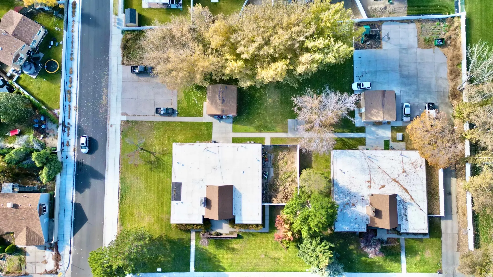 Aerial perspective showcasing multiple properties with expansive green lawns