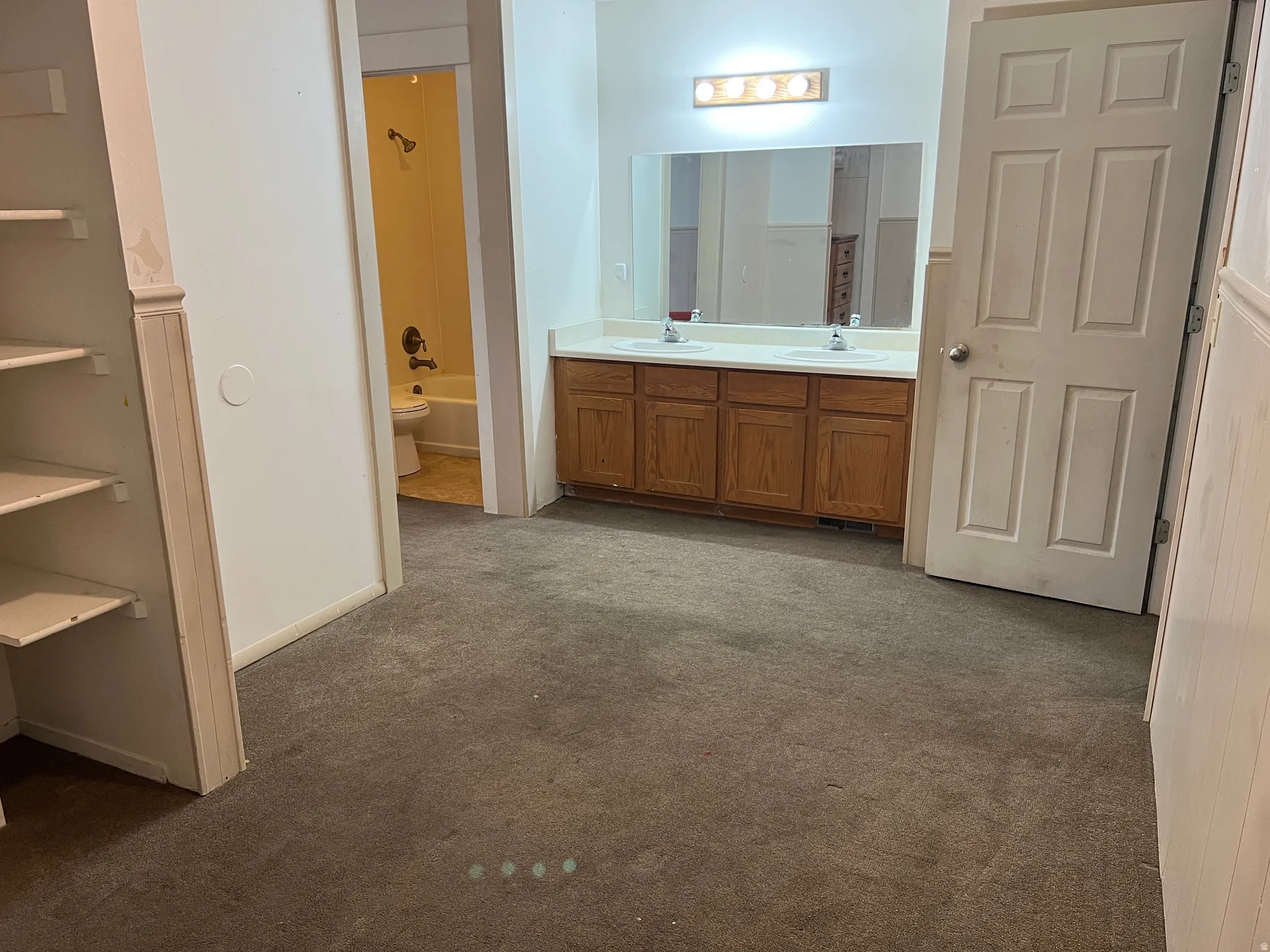 Double vanity with laminate countertops and wood-finish cabinetry