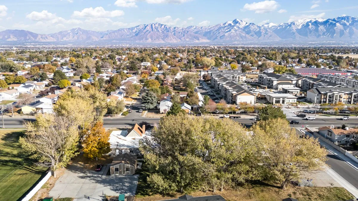 Expansive suburban landscape featuring a mix of residential properties, commercial structures, and mature trees
