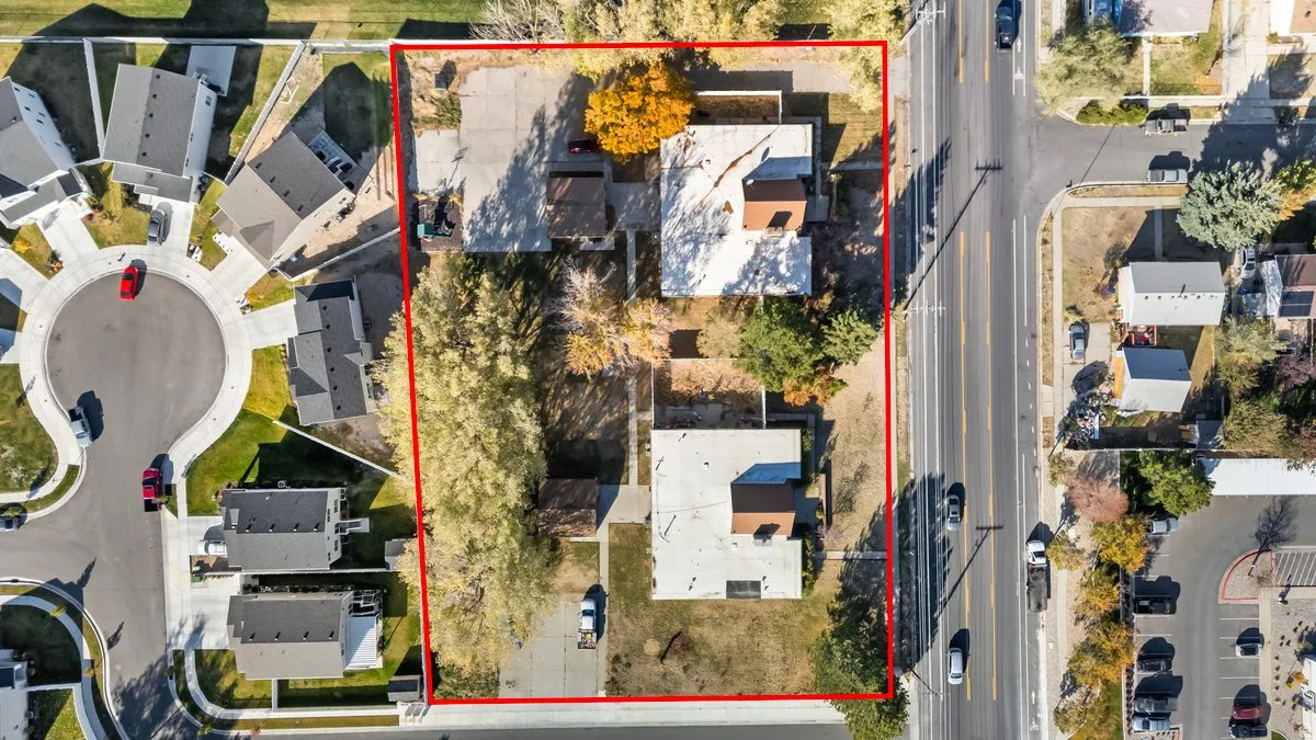 Expansive lot featuring two structures, mature trees, and direct road frontage
