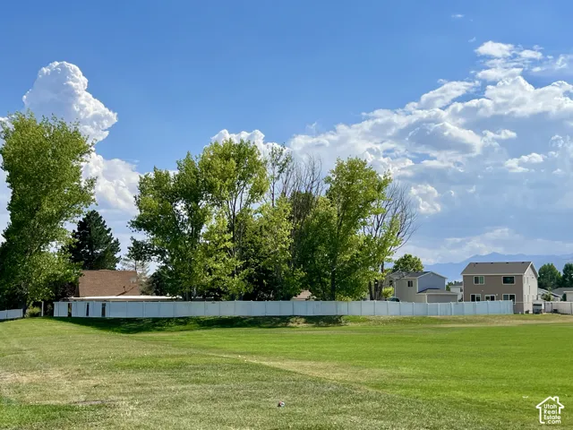 Expansive green space with distant mountain ranges and a clear sky backdrop
