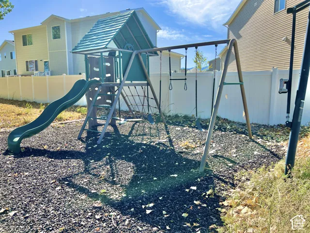 Outdoor play structure featuring a slide, swings, and climbing elements